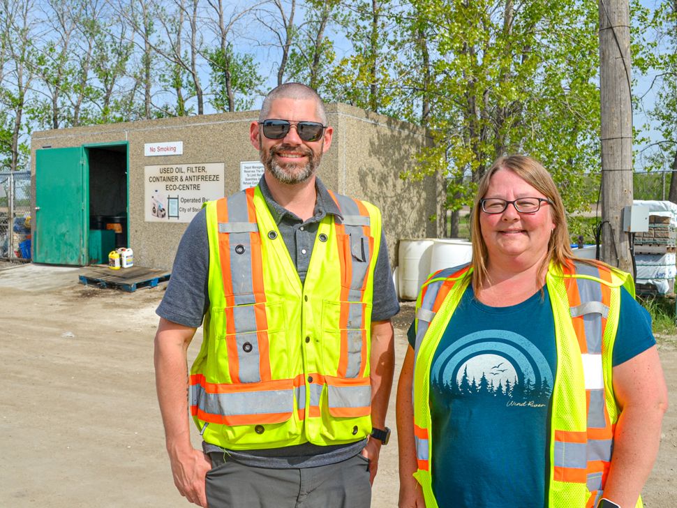 Brian Davis and Cindy Kehler standing in front of a building in high vis vests